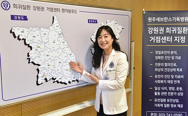 희귀질환 강원권 거점센터 환자분포도 지도 앞에서 웃고있는 교수 - 원주세브란스기독병원 강원권 희귀질환 거점센터 지정 정밀유전자 분석, 정확한 진단 및 치료, 전문의 협의진료, 최상의 건강상태 목표, 유전자 진단 및 치료비 사회복지 재정 연계, 일상 식이, 영양, 운동, 활동 관련 전문가 상담, 유전질환 유전상담, 가족력 질환 정보 제공